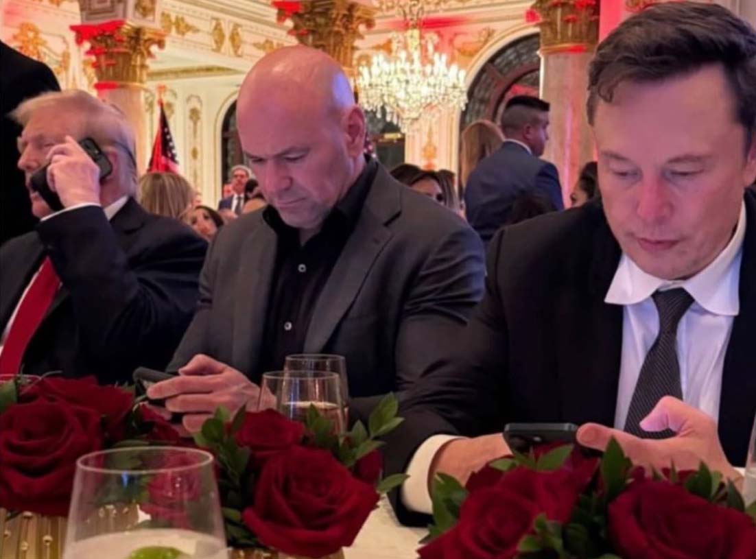 Donald Trump und Elon Musk bei einer festlichen Veranstaltung, vertieft in ihre Smartphones – eine seltene Momentaufnahme zweier einflussreicher Persönlichkeiten.