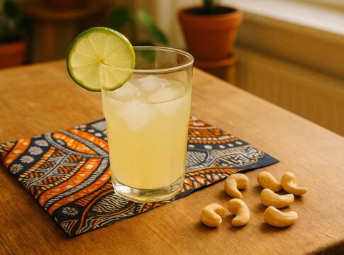 Cashew-Limonade im Glas mit Limettenscheibe, daneben Cashewkerne – inspiriert von Akoua aus Die Höhle der Löwen
