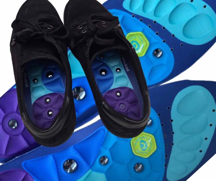 Akusoli Einlegesohlen mit sichtbaren Magnetpunkten und Dämpfung direkt in schwarzen Schuhen eingesetzt