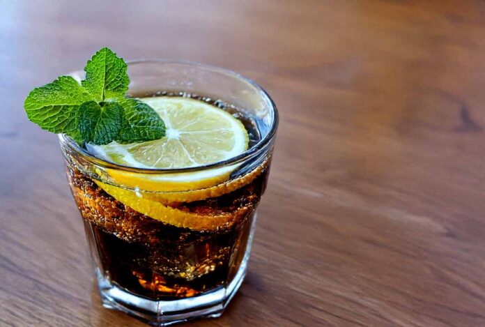 Cola Zero in ein Glas mit Zitronen und Eiswürfeln